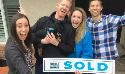 Lauren Ward and family celebrating their home purchase with a Steele San Diego Homes SOLD sign